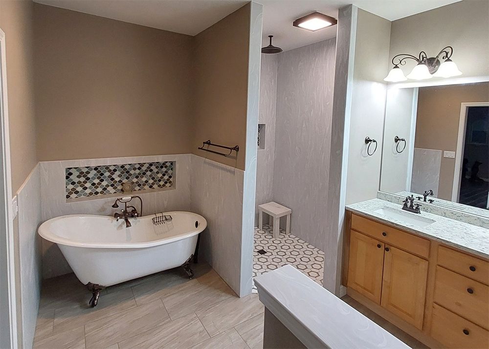 A bathroom with a bathtub , sink , and shower.