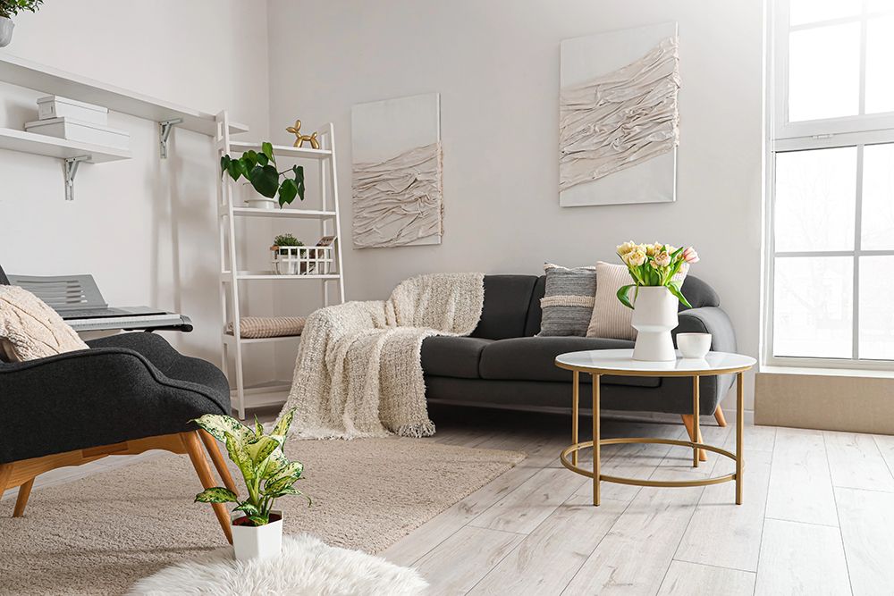 A living room with a couch , chair , coffee table and window.