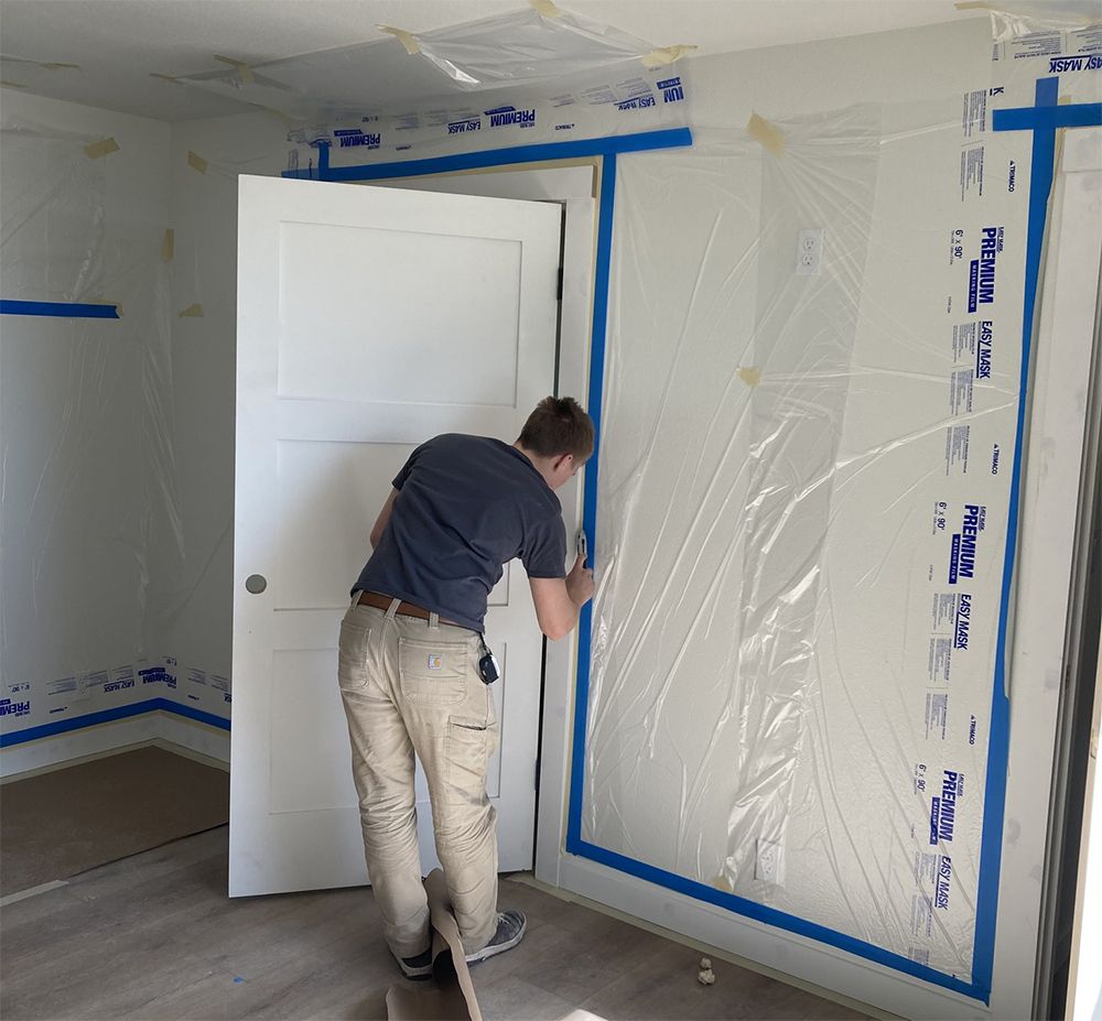A man is measuring a wall with a tape measure