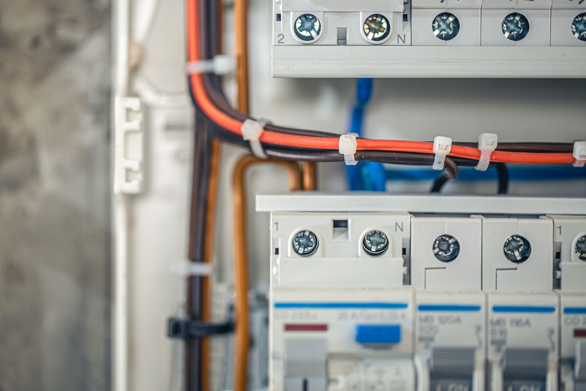 Electrical panels with red and blue cables in a utility cabinet