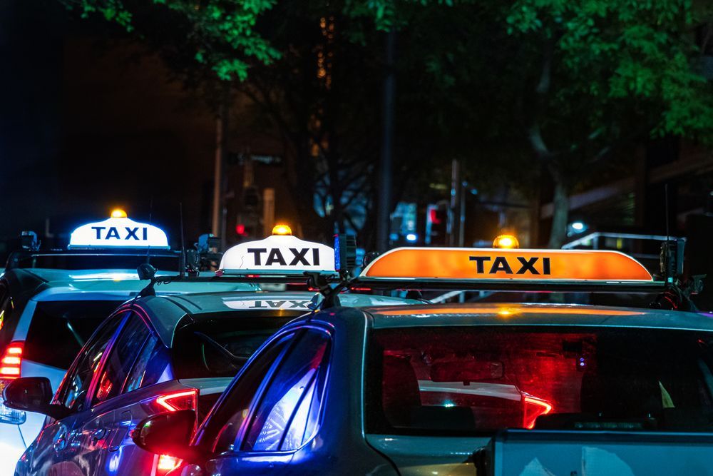 Taxis lined up at night, illuminated taxi signs atop each car — Precision Tuning in Bungalow, QLD