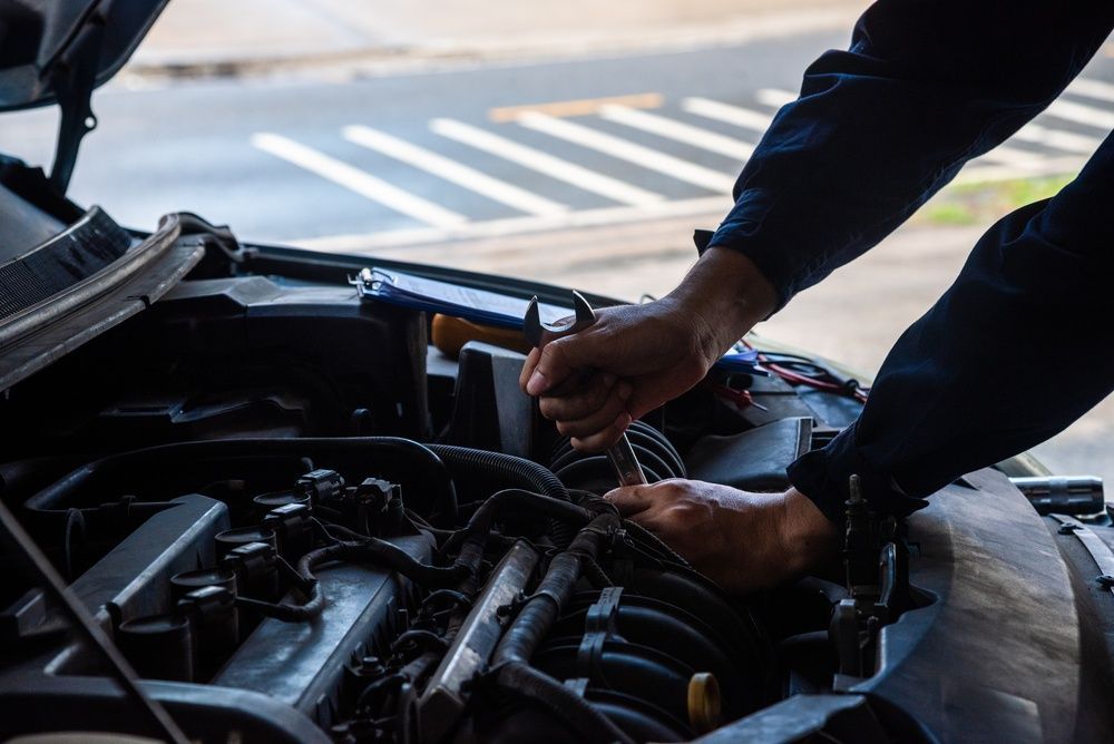 Person working on a car engine with a wrench under the hood — Precision Tuning in Bungalow, QLD