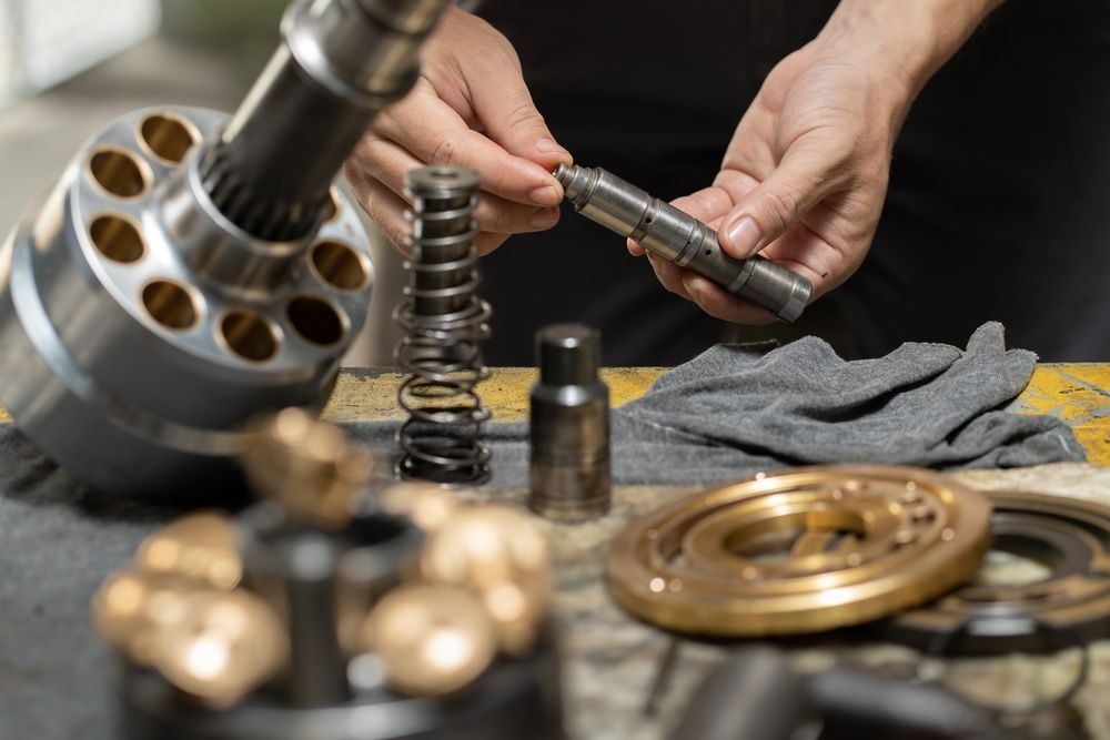 Person Assembles Hydraulic Pump Parts on A Workbench — Precision Tuning in Edmonton, QLD