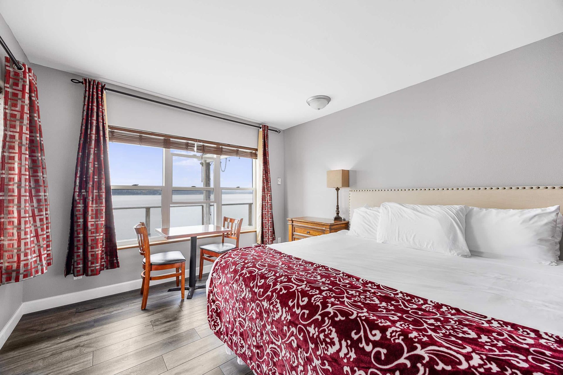 A hotel room with a king size bed and a large window