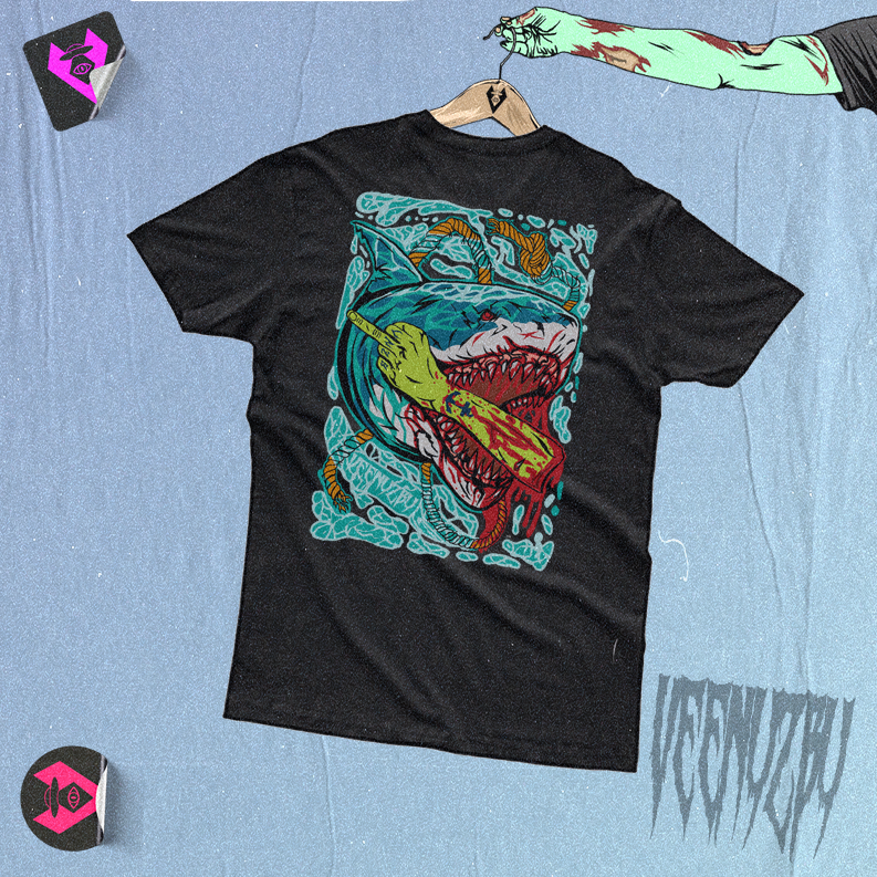 Camiseta preta com estampa colorida de monstro, estendida sobre um fundo azul com adesivos próximos.