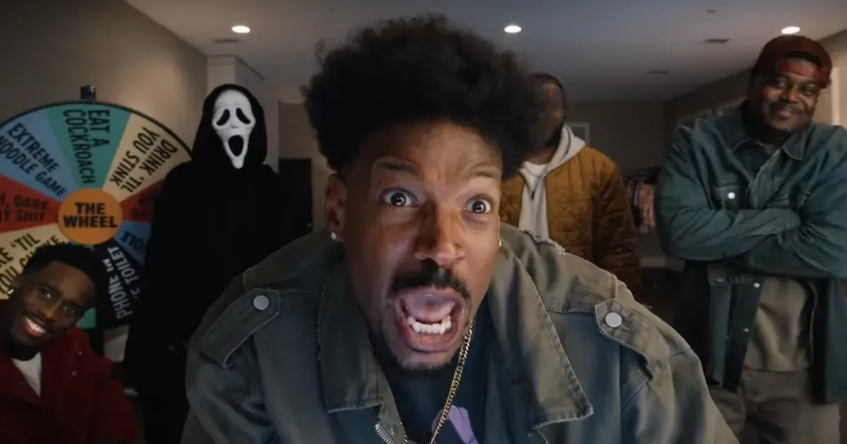 Três pessoas em um quarto escuro, uma delas gritando em direção à câmera, com uma roleta de jogos e uma máscara do Ghostface ao fundo.