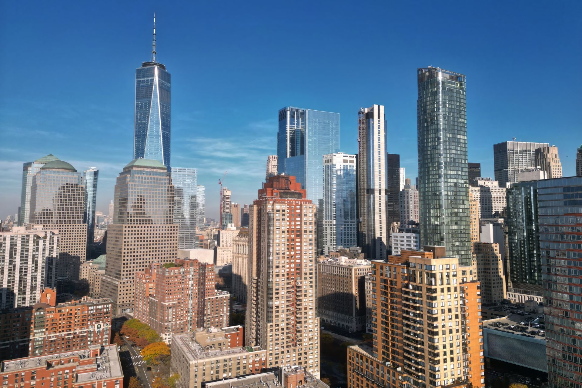 New York City skyline with One World Trade Center and high-rise buildings under a clear blue sky