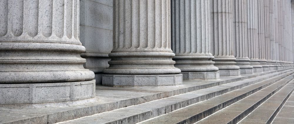 Row of classical columns with steps leading up, gray stone.