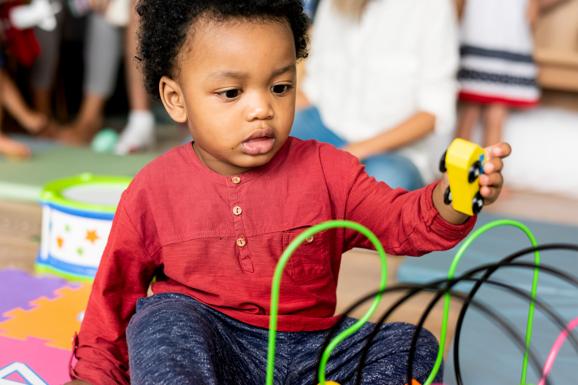 Little boy playing toys in the playroom.