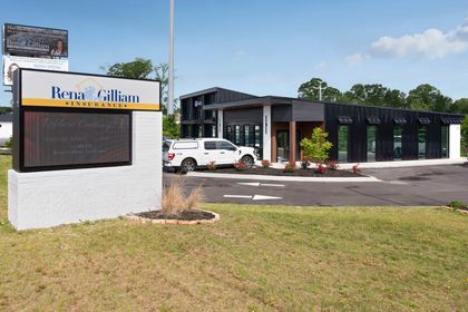 Exterior view of Rene Gilliam at Fine Dental, modern building with a sign and a white truck.