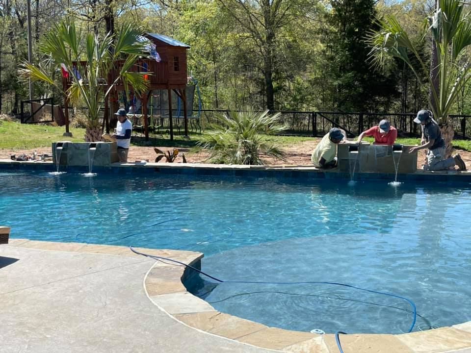 A group of people are working on a swimming pool in Texarkana, TX