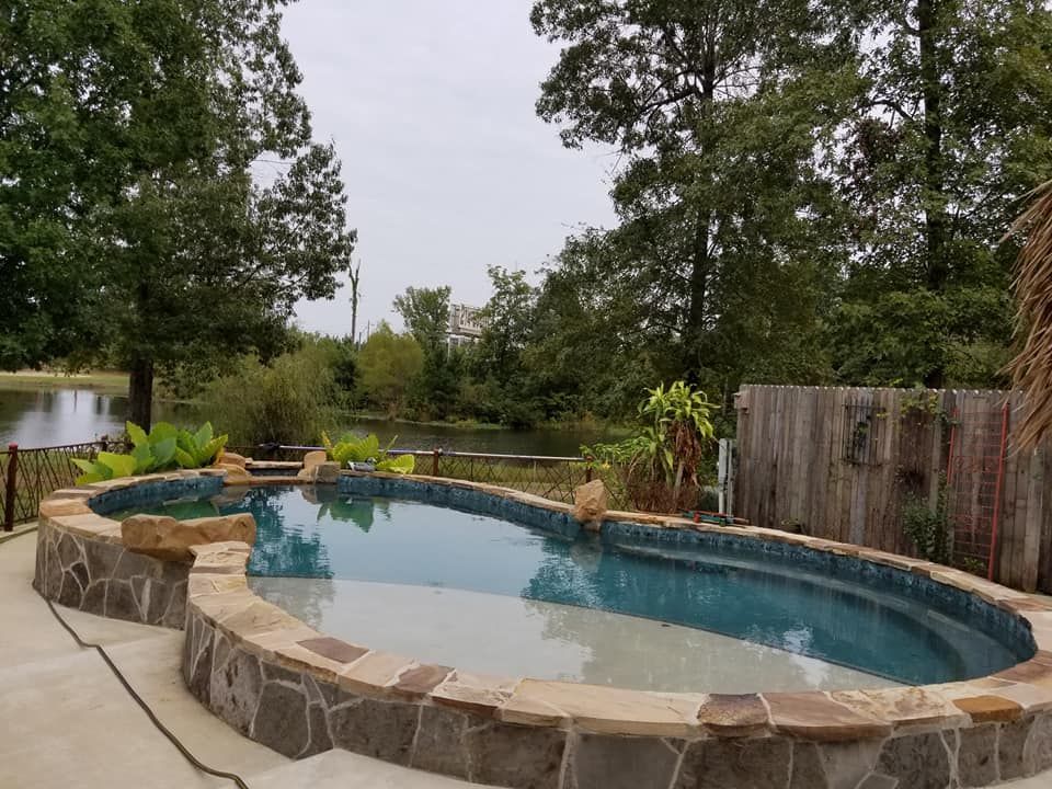 A large swimming pool surrounded by trees and a wooden fence in Texarkana, TX.