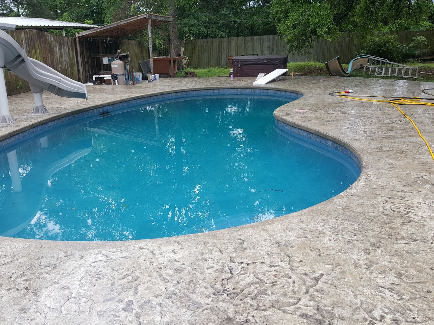 A large Texarkana, TX swimming pool with a slide in the backyard