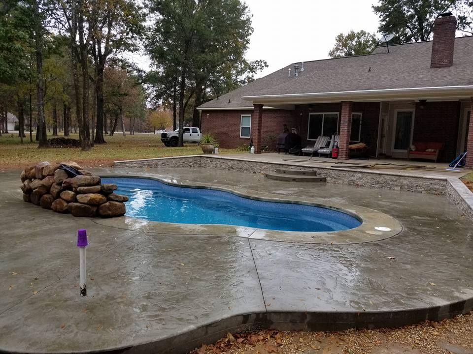 A brick house with a large swimming pool in front of it in Texarkana, TX