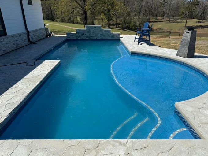 A large swimming pool withon a deck in Texarkana, TX