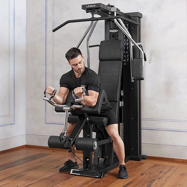A person in a black t-shirt performs a bicep curl exercise on a professional black cable gym machine.