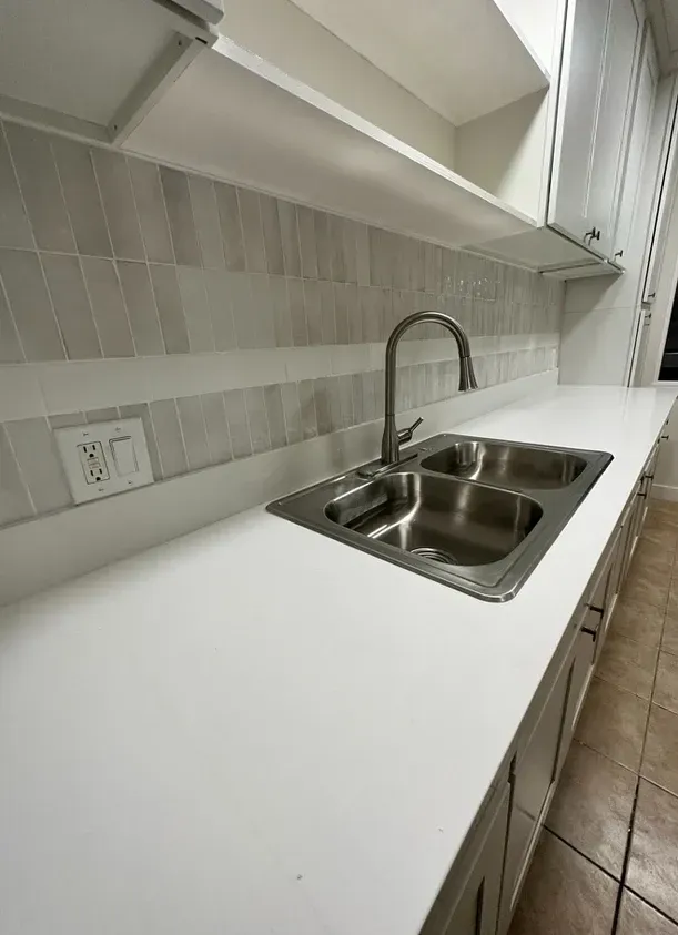 A kitchen with a stainless steel sink and a faucet.
