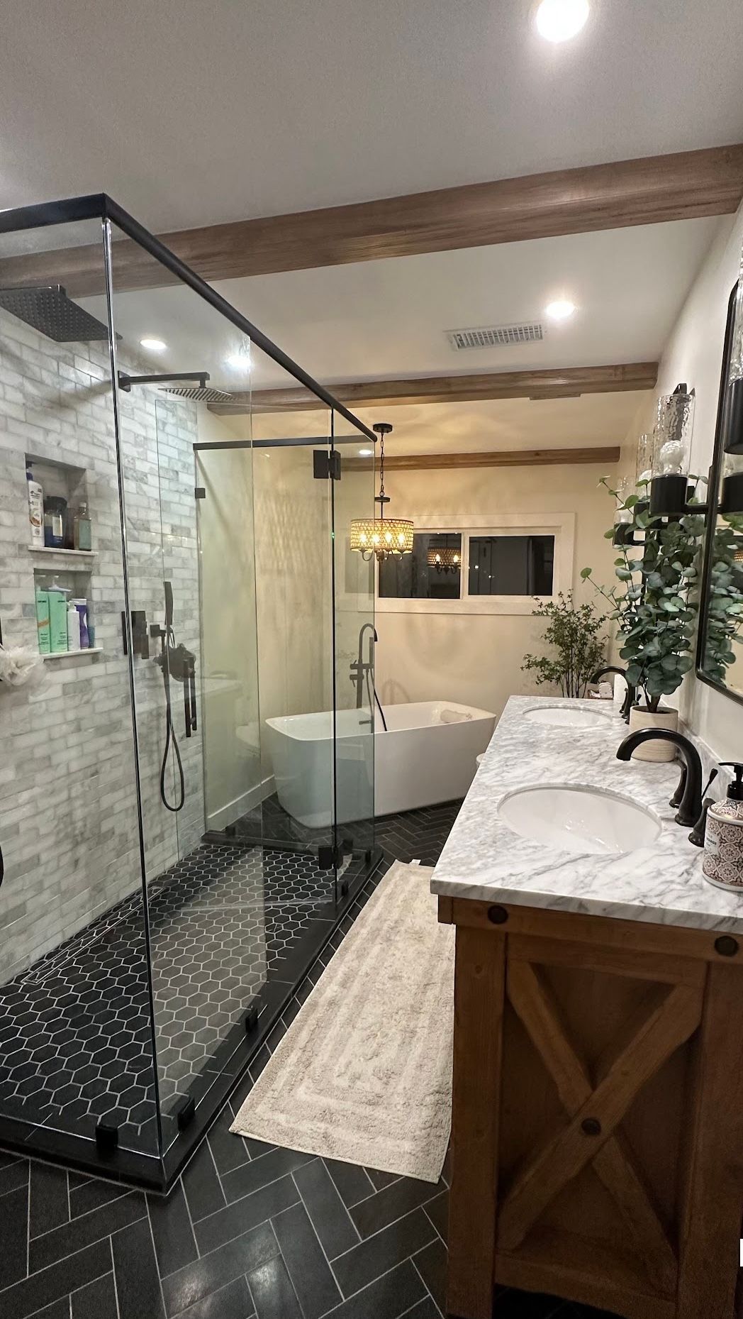 A bathroom with two sinks , a tub , and a walk in shower.