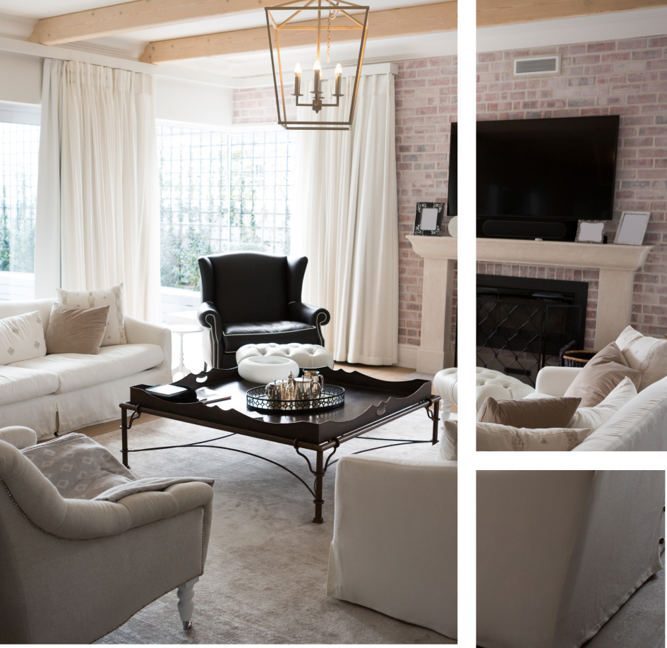 A living room with white furniture and a fireplace