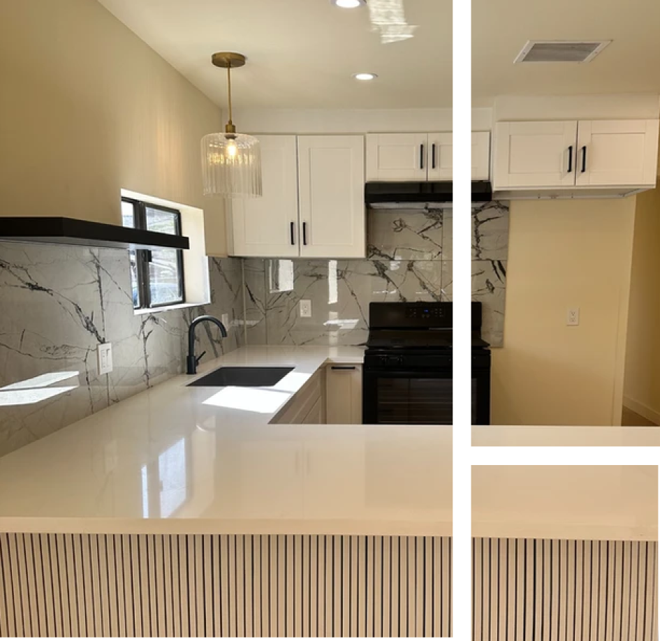 A kitchen with white cabinets and marble counter tops