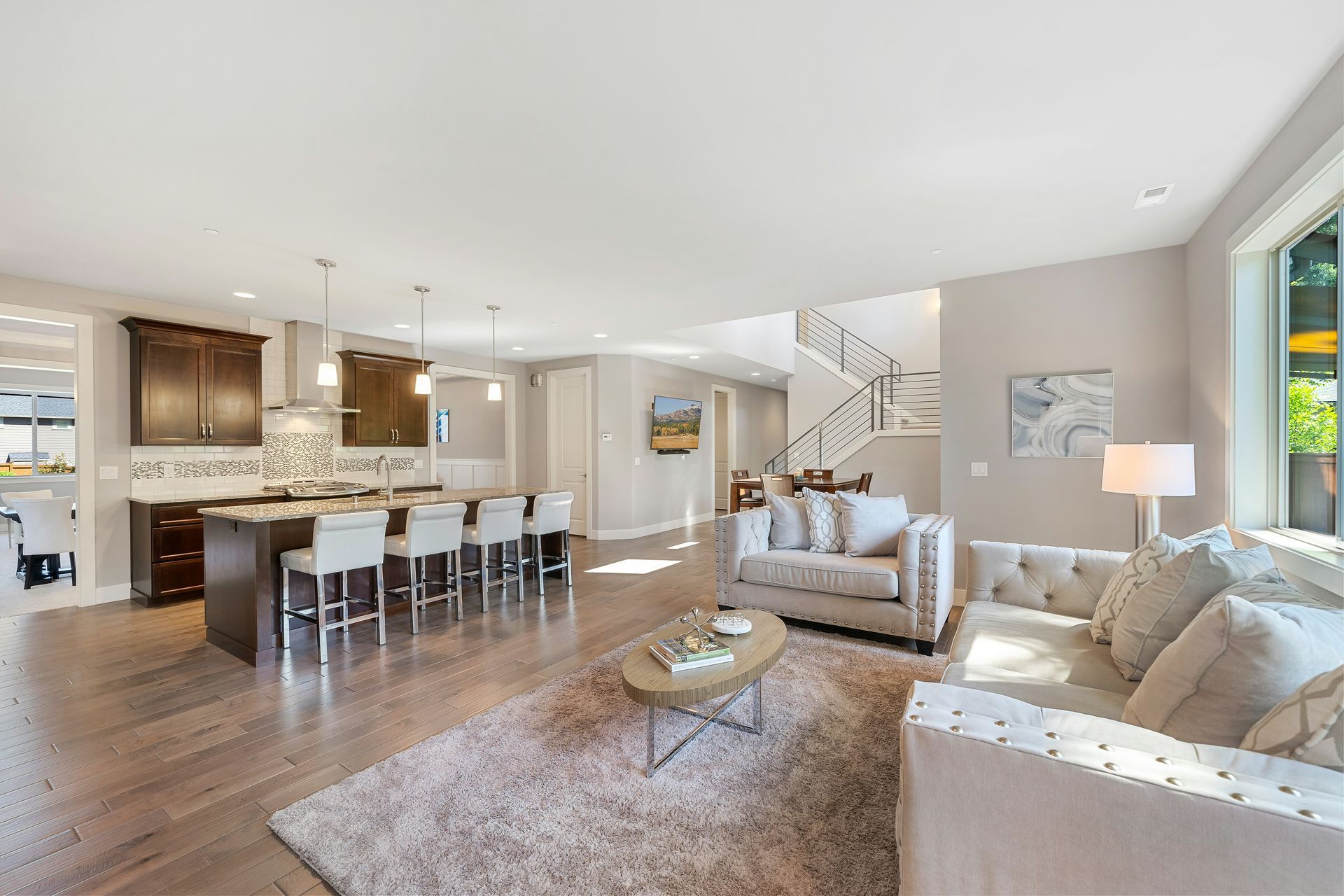 A living room with a couch, table, chairs and a rug.
