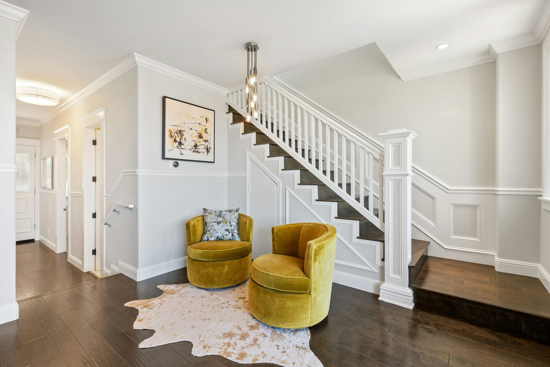 A living room with a staircase and two chairs.