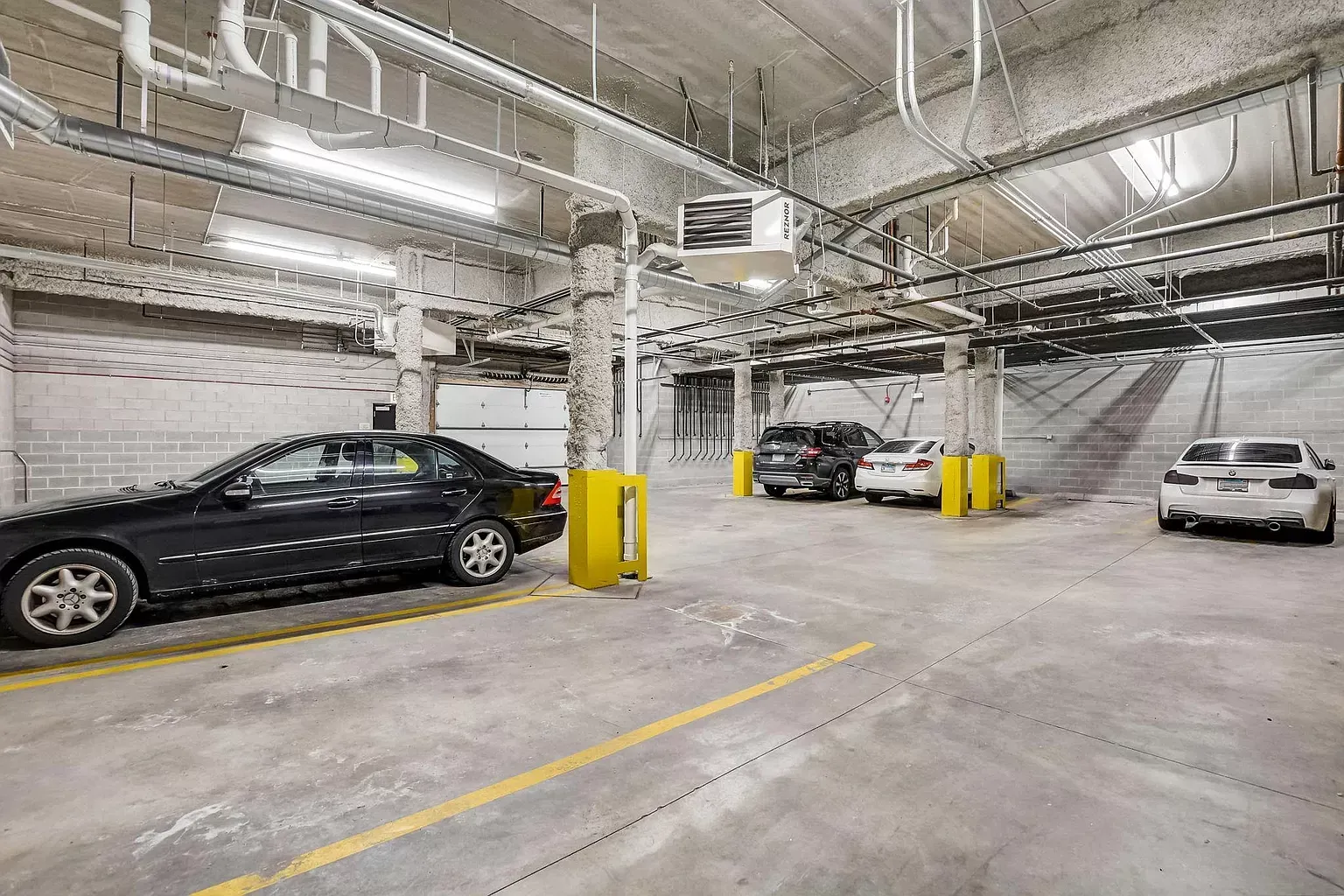 a row of cars are parked in a parking garage .