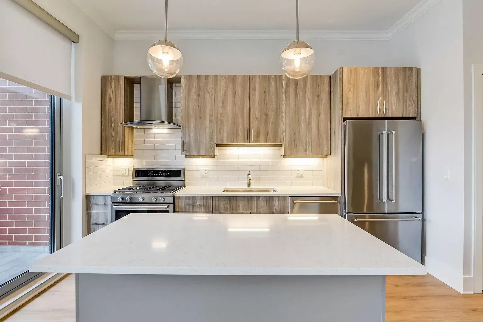 a kitchen with stainless steel appliances , wooden cabinets and a large island .