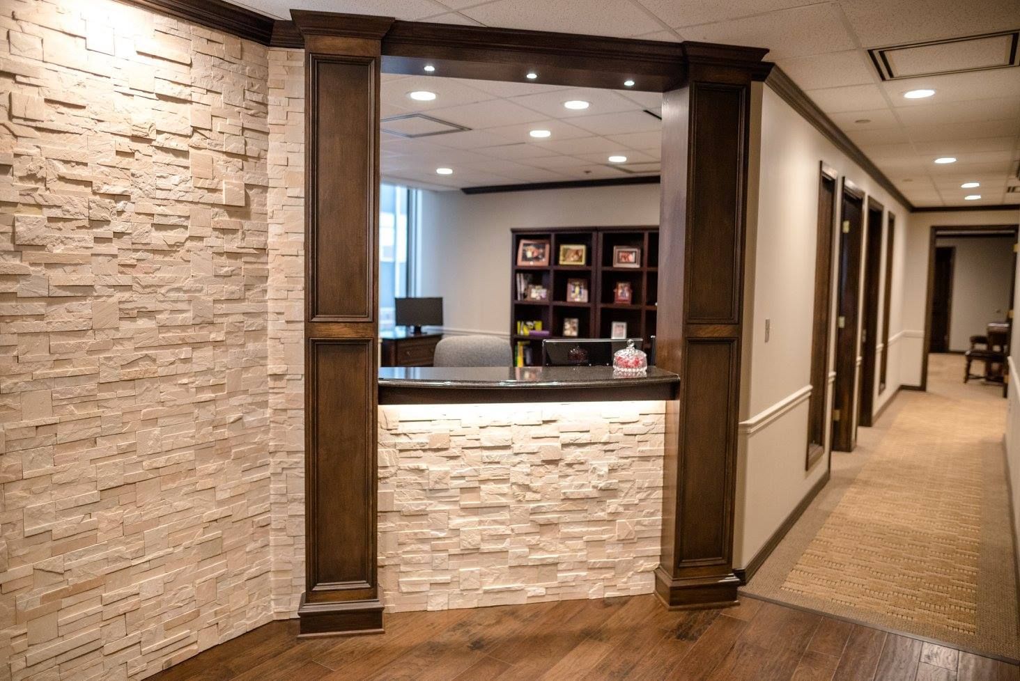 Hotel lobby hallway with stone walls, reception desk, and carpeted corridor