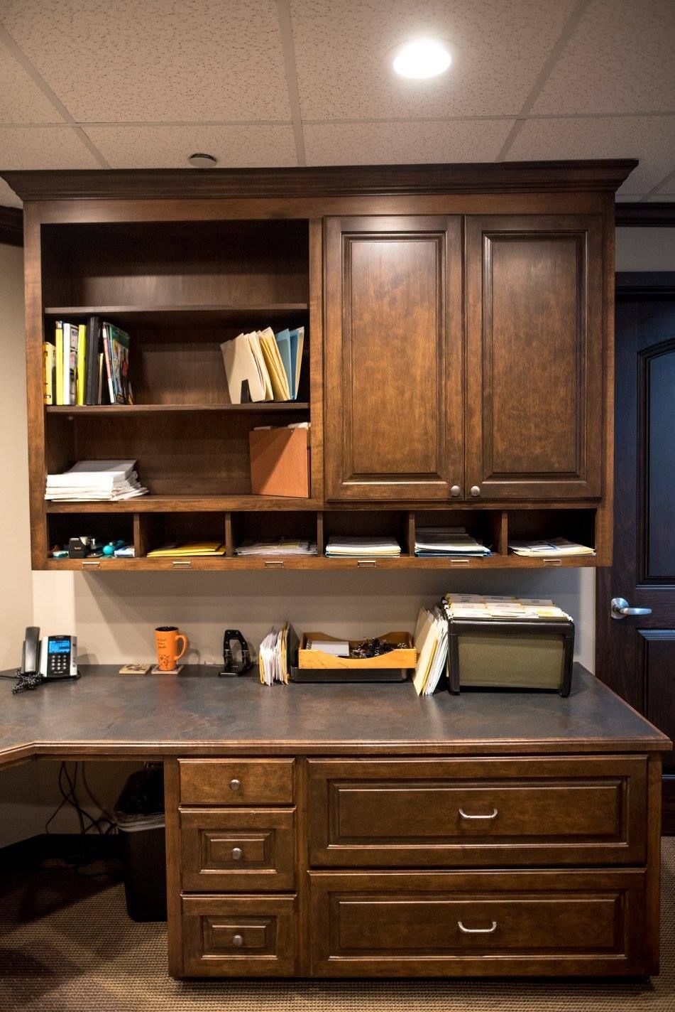Wooden kitchen cabinet and counter with shelves, drawers, and countertop appliances in a home kitchen.