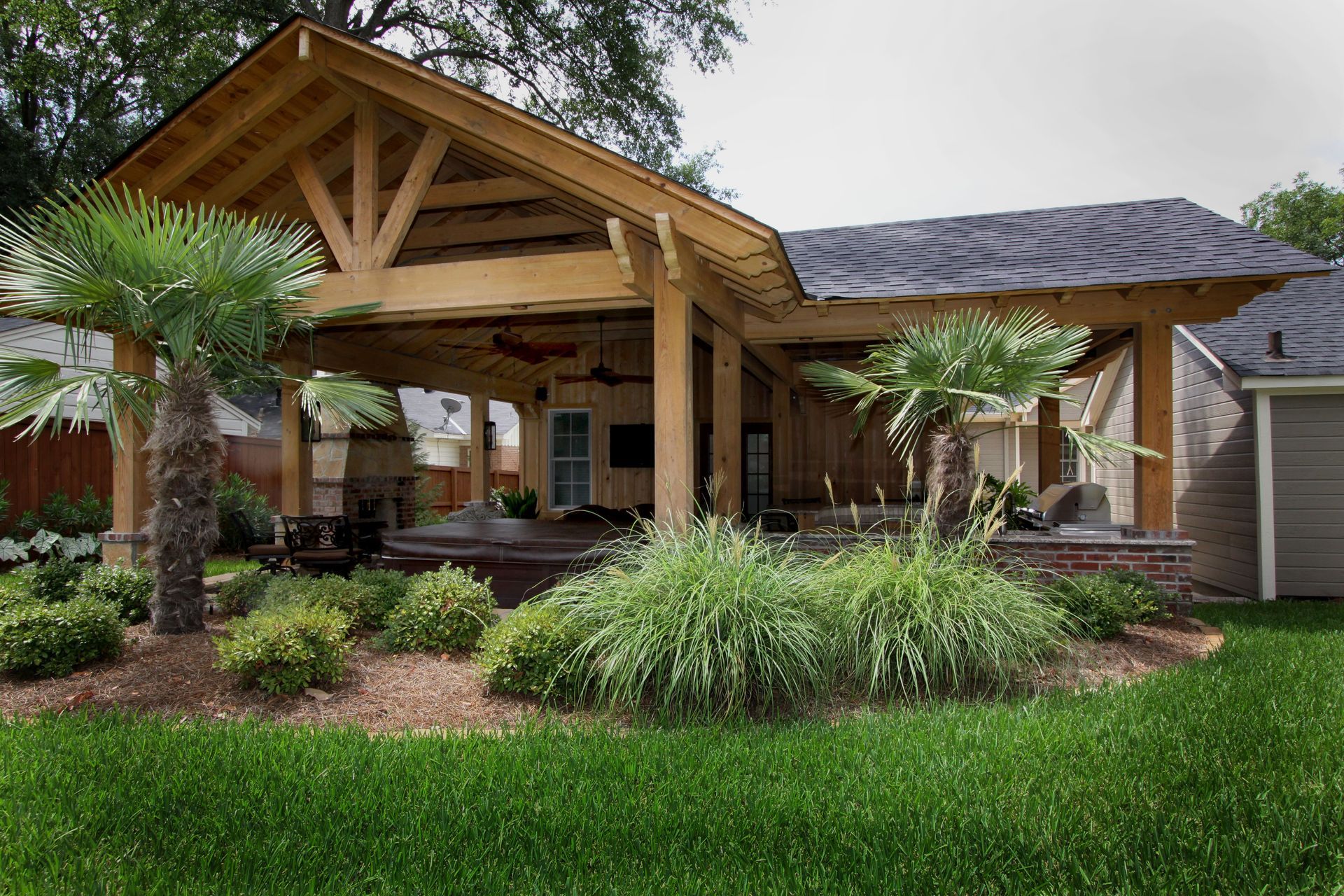 Wooden pavilion with a gabled roof and landscaped garden in front of a house
