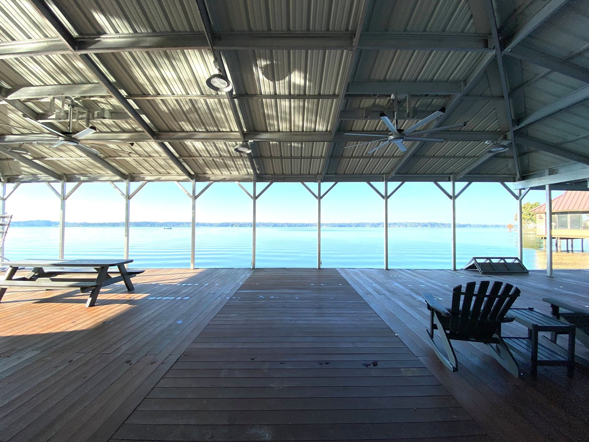 Shaded beach pavilion with picnic tables and chairs overlooking the ocean