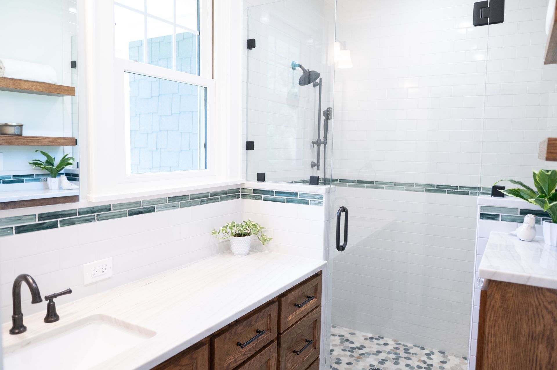 Bright white bathroom with walk-in shower, double sink vanity, window, and dark wood cabinets
