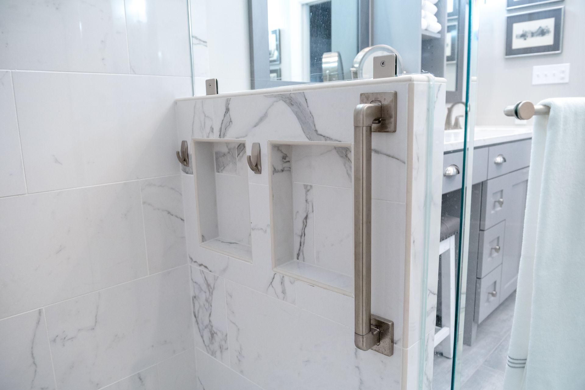 Marble shower door with metal handle in a bright bathroom
