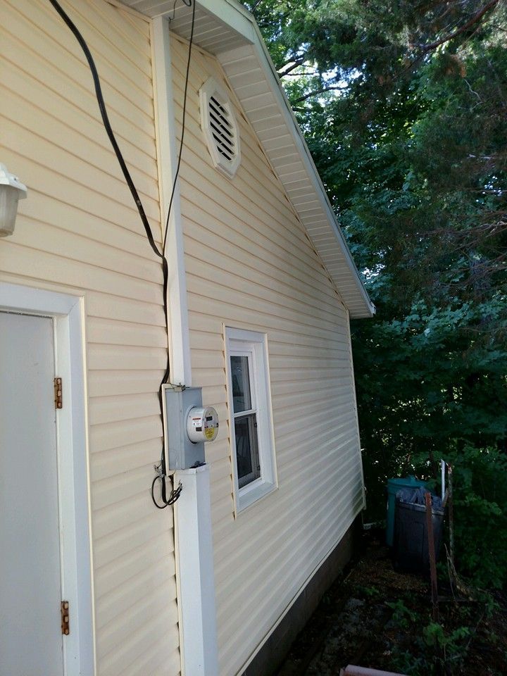 The side of a house with a electrical box on it