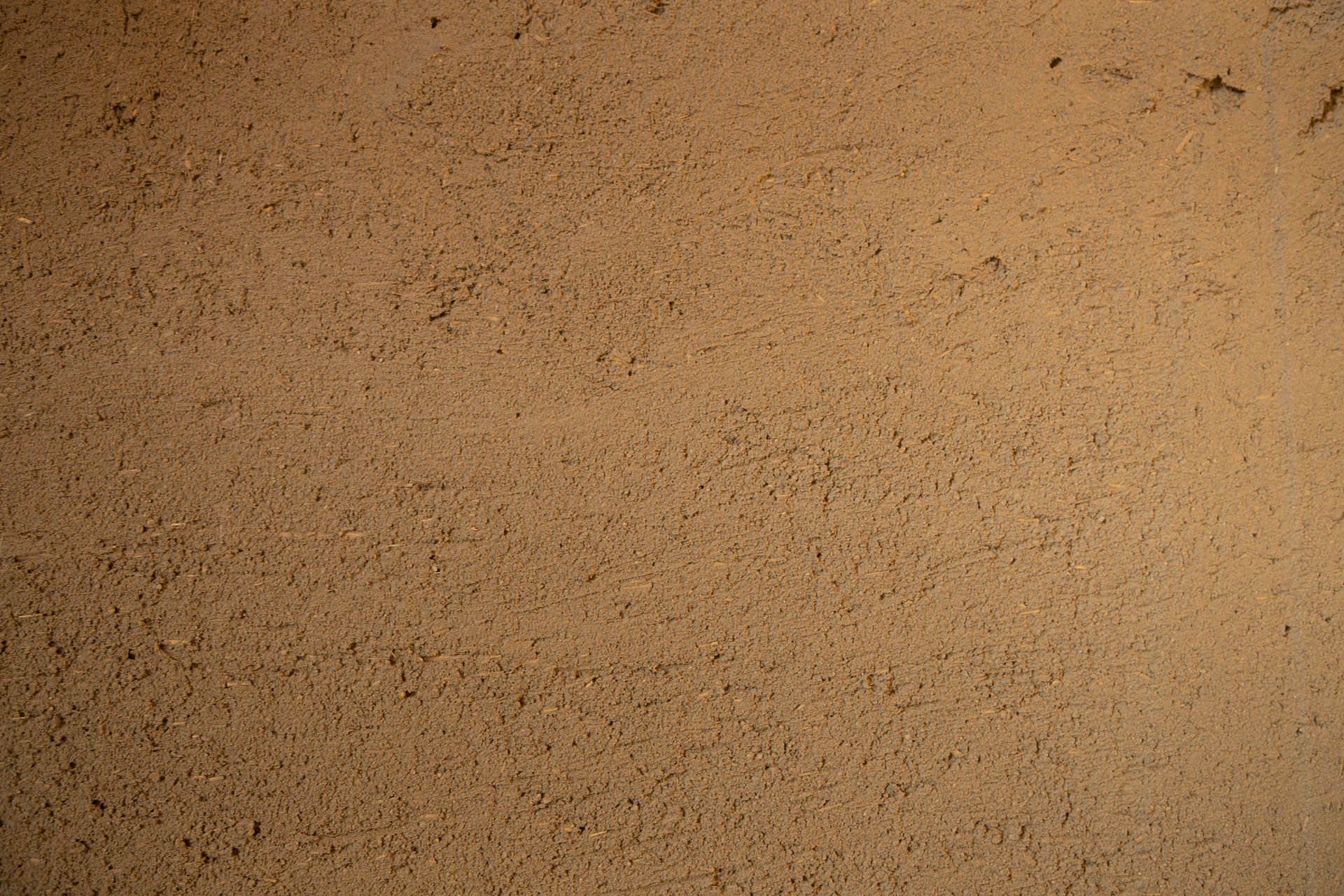 Braune strukturierte Wand, möglicherweise Lehmziegel oder Gips.