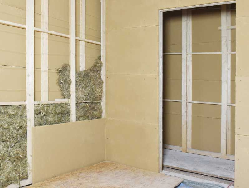 Innenwandkonstruktion mit sichtbarem Holzrahmen, Isolierung und Trockenbau.