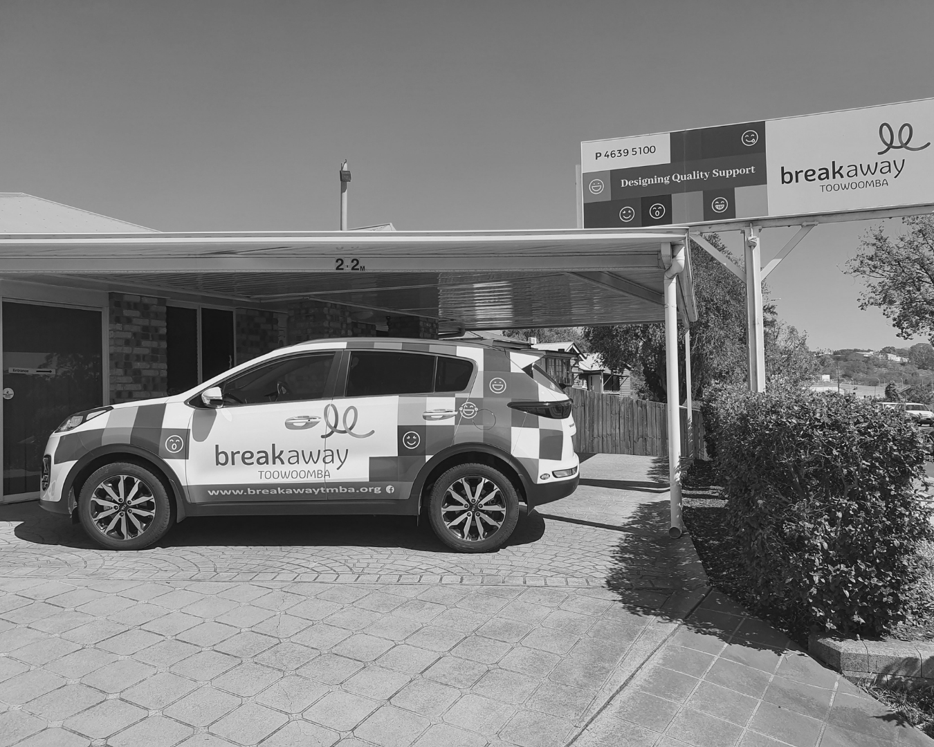 Delivery van parked under a storefront awning with “break…” branding on the side