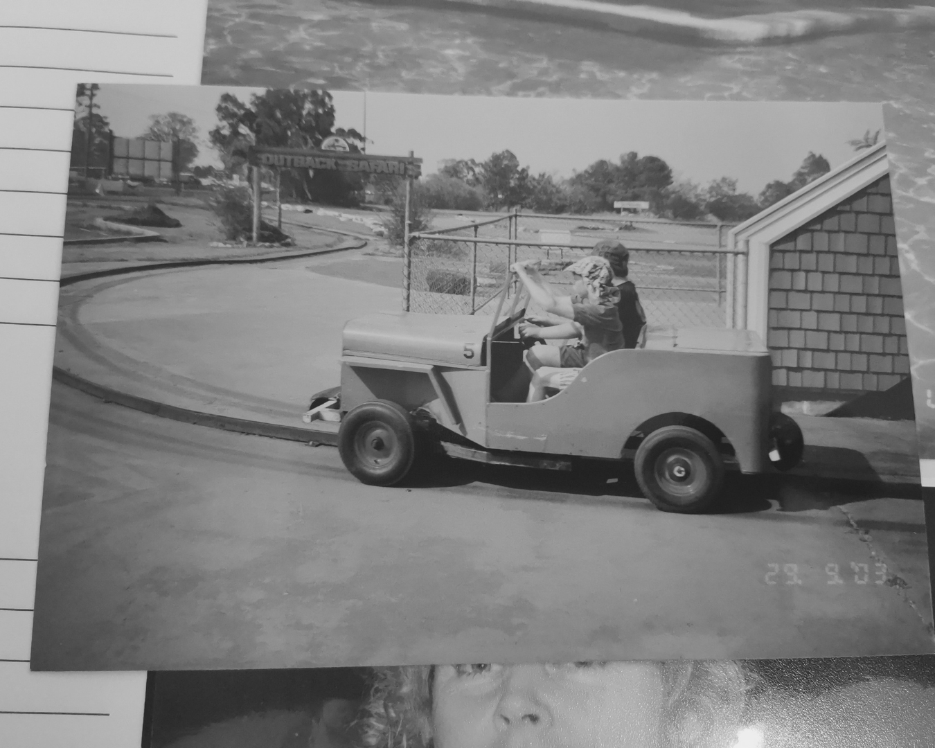 Golf cart driving on a curved street in a suburban neighborhood, with a person seated inside.
