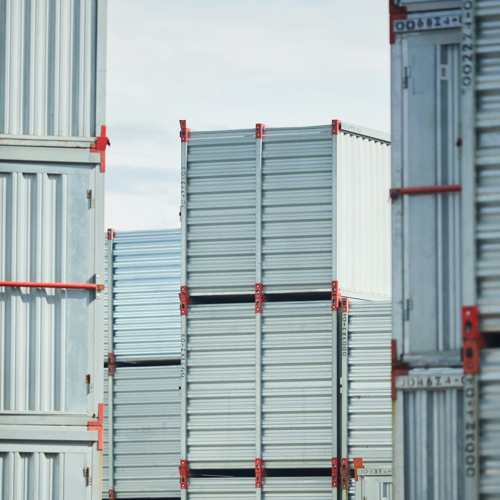 Stacked silver shipping containers in a storage yard