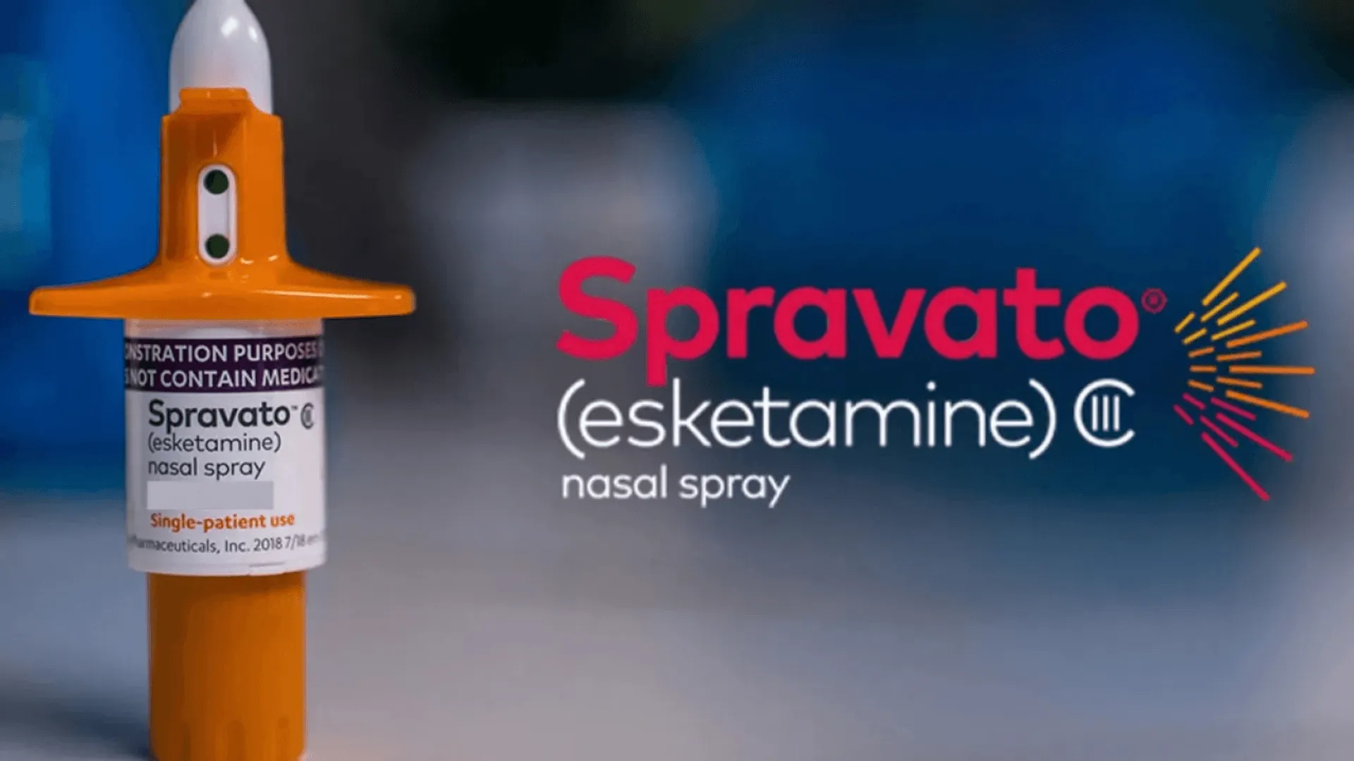 Spravato (esketamine) nasal spray bottle with orange applicator on a blue background