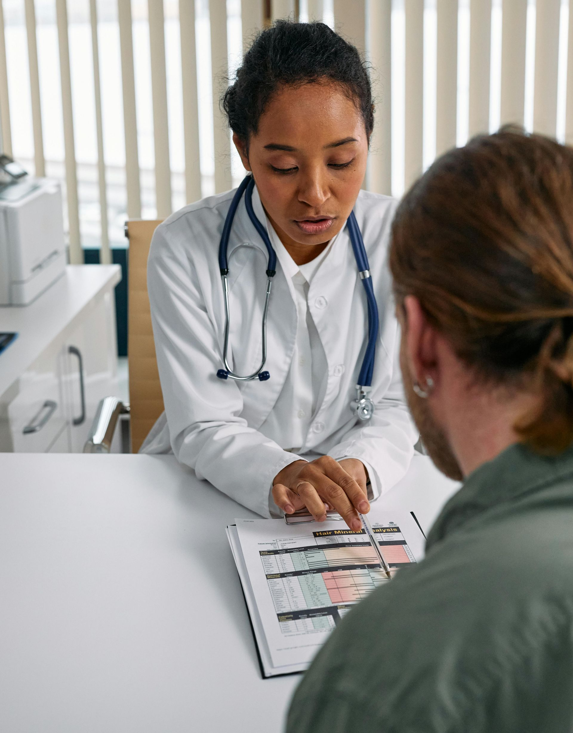 Doctor reviewing medical charts with a patient in a clinic office
