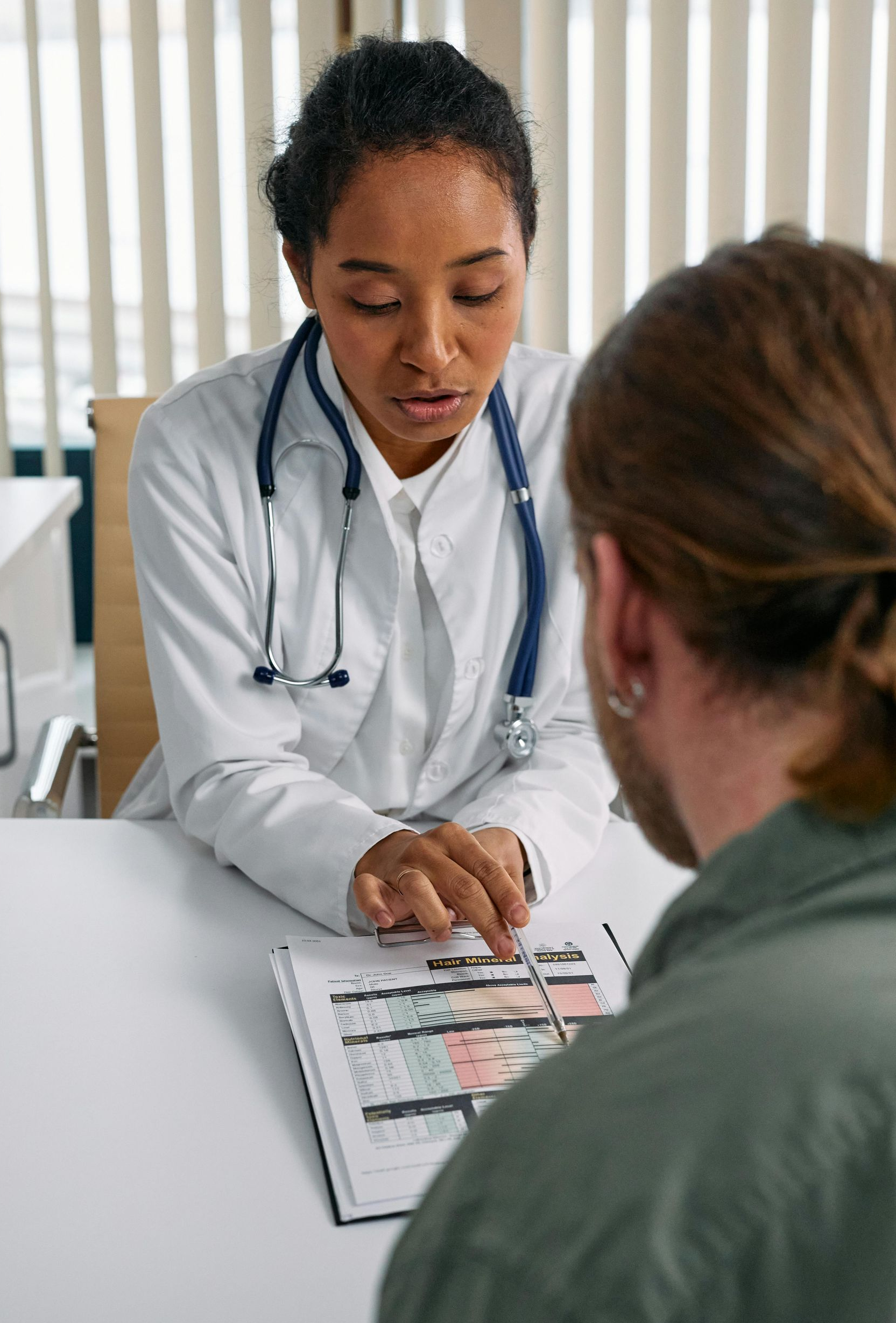 Doctor reviewing medical charts with a patient in a clinic office
