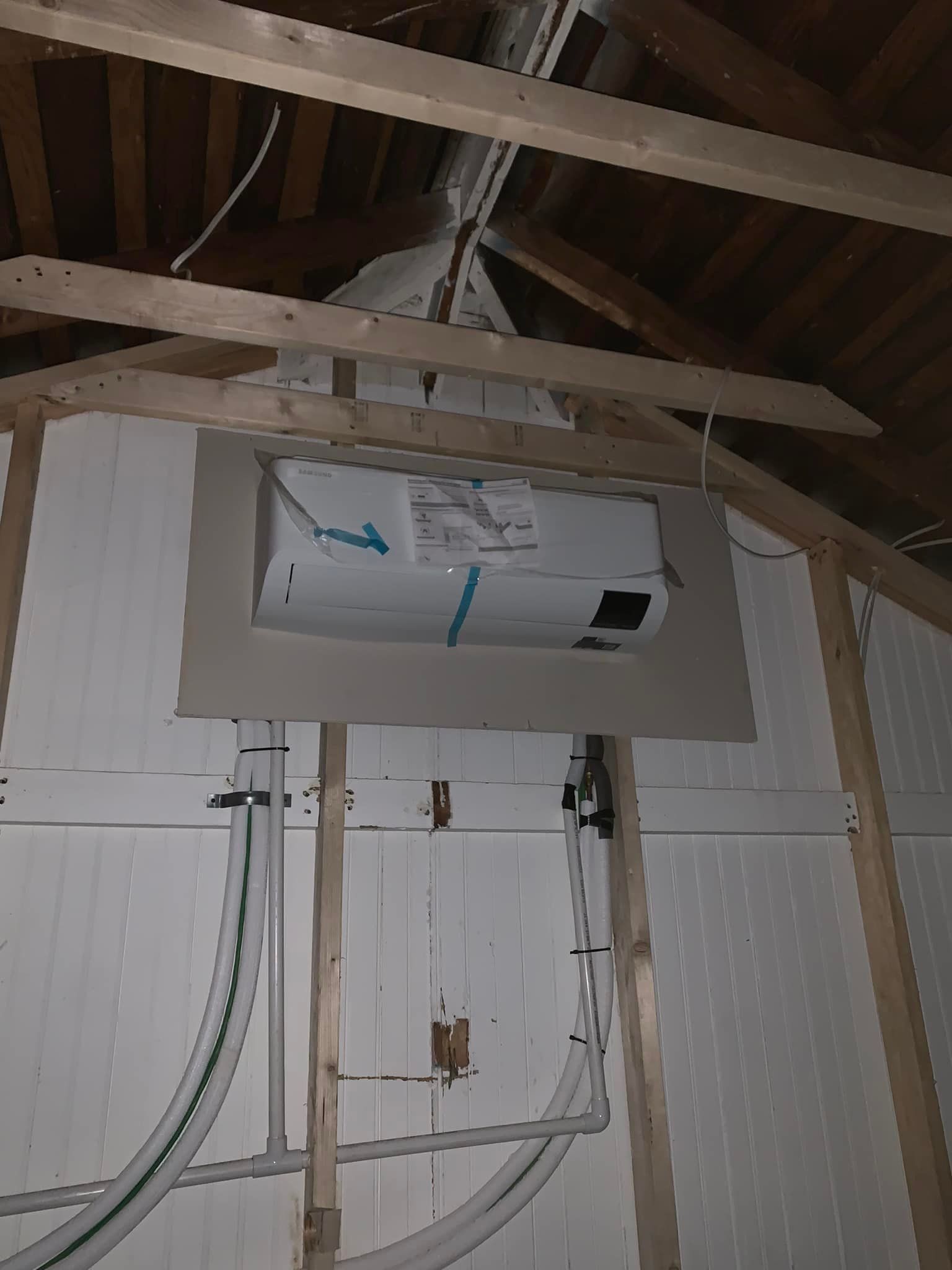 A white box is hanging from the ceiling of a building.