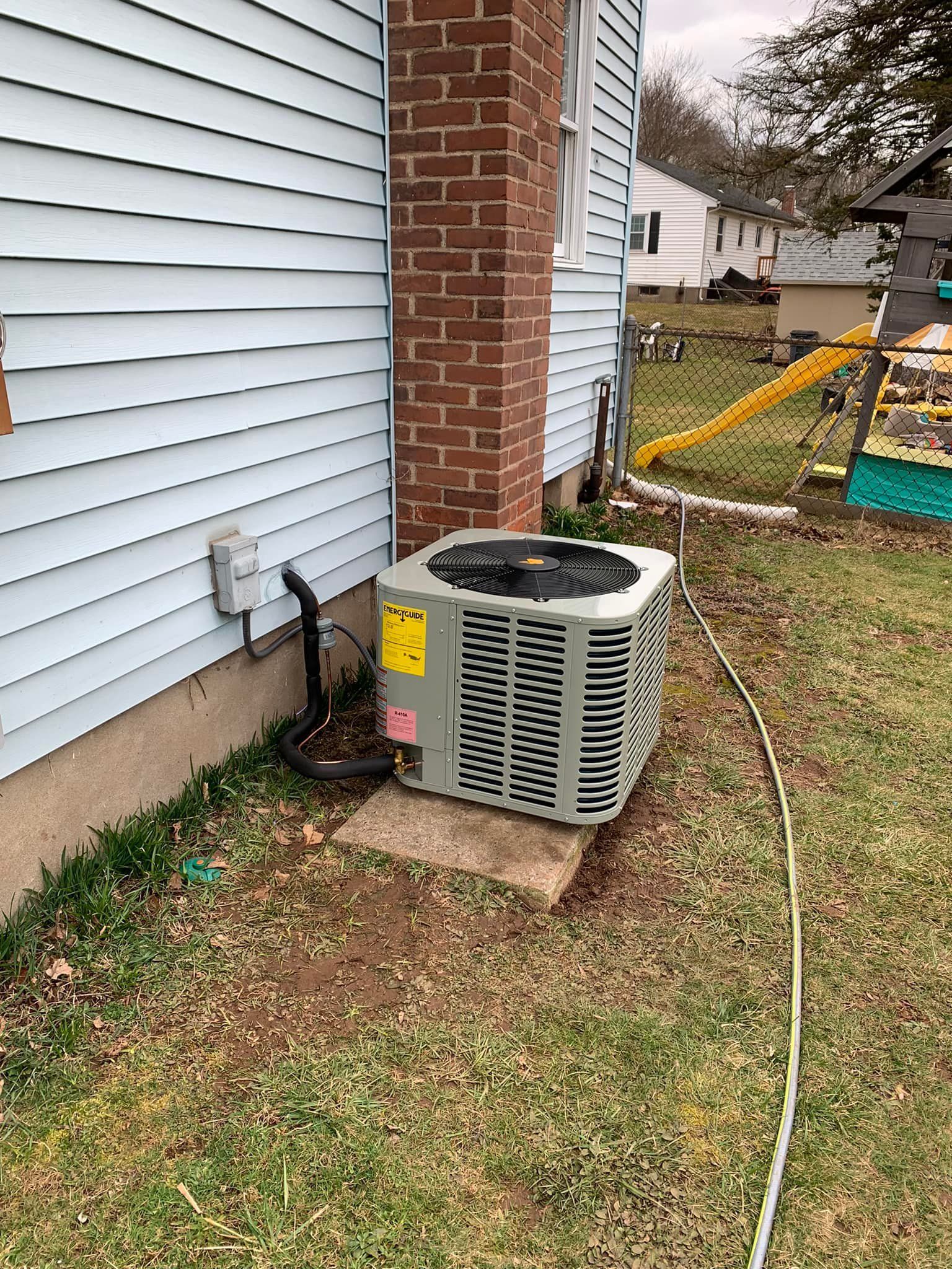 An air conditioner is sitting on the side of a house.