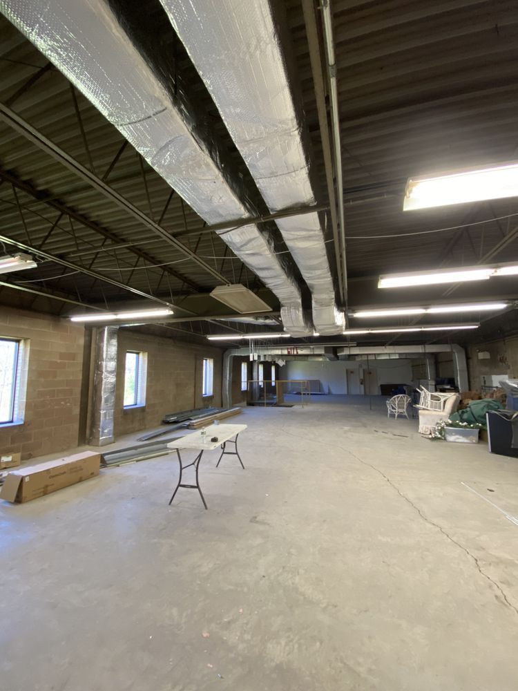 A large empty room with a table and chairs in it.