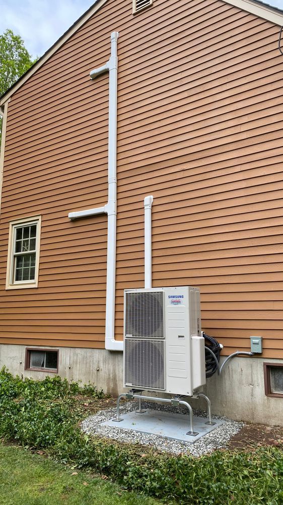 A large air conditioner is installed on the side of a house.