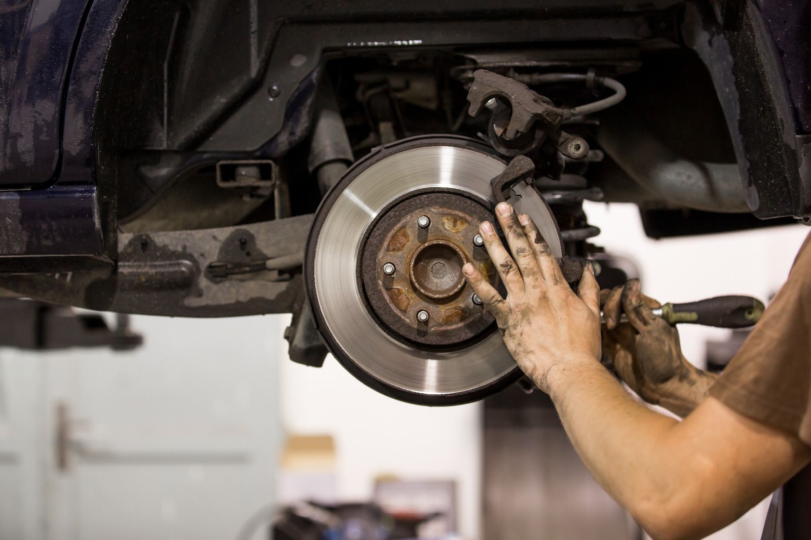 Car interior with exposed steering wheel and dashboard being inspected by repair tools