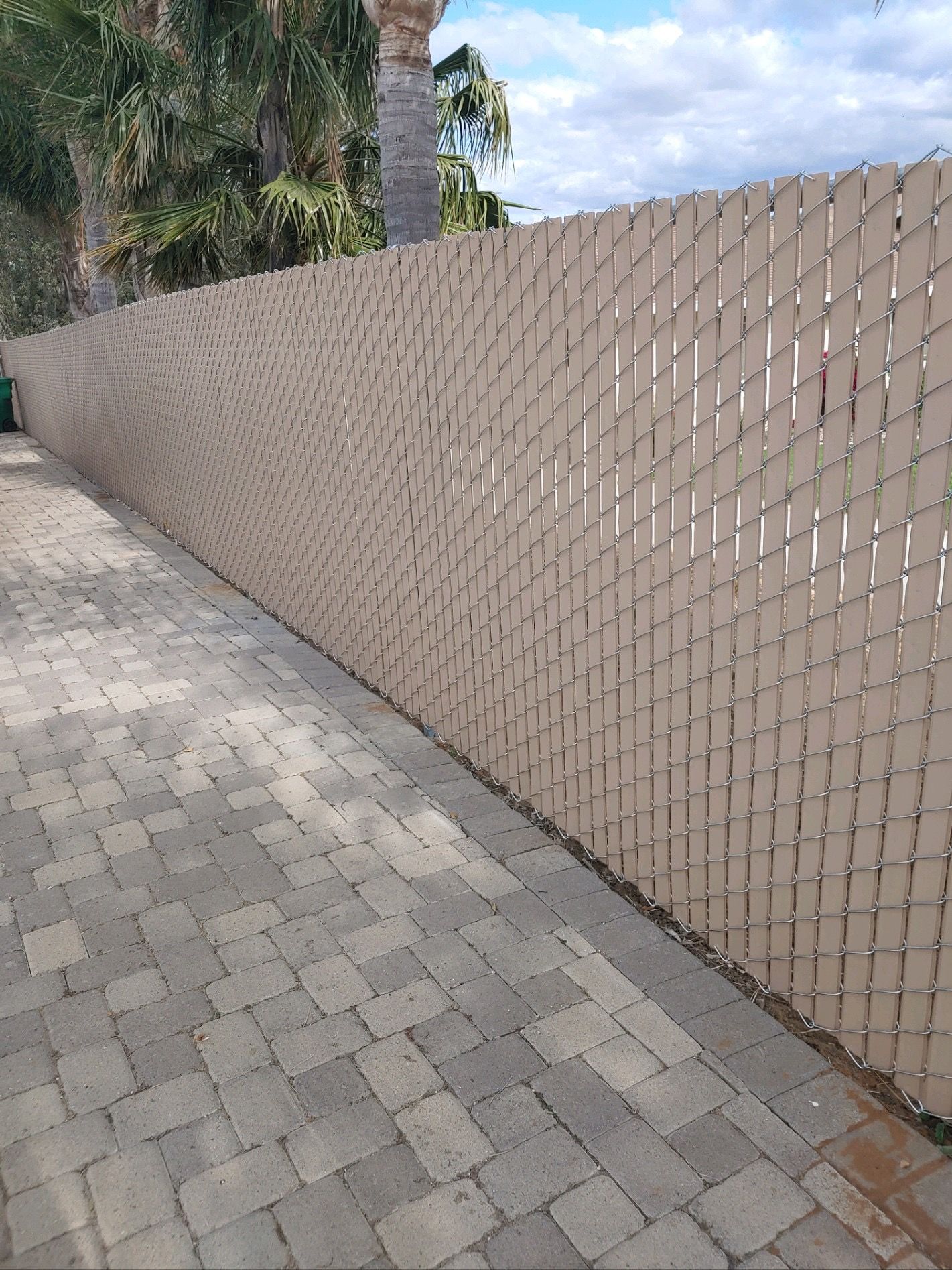 A Chain Link Fence Is Along the Side of a Brick Driveway — Riverside, CA — Elrod Fence Co