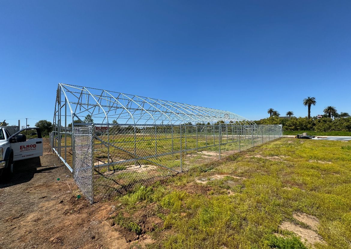 A Barbed Wire Fence Is Being Built in a Field — Riverside, CA — Elrod Fence Co